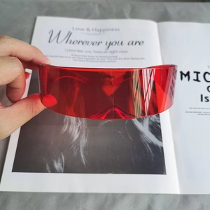 Détail de lunettes de soleil cyberpunk rouges avec un design futuriste à verre unique