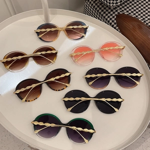 Fashionable round oversized sunglasses with gold leaf temple accents in various colors