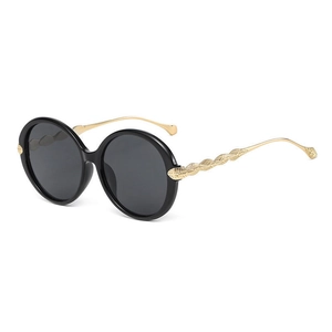 Fashionable round sunglasses with black frames and engraved gold metal temples