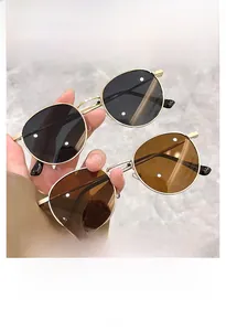 Detail of round metal sunglasses with double bridge design in black and brown lenses