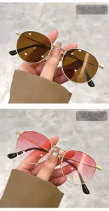 Detail of vintage oval metal sunglasses with gold frames in tea and gradient pink lenses