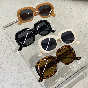 Détails de lunettes de soleil ovales vintage en quatre couleurs sur un support clair