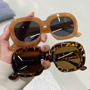 Détail de lunettes de soleil ovales rétro en résine épaisse, écaille et ambre