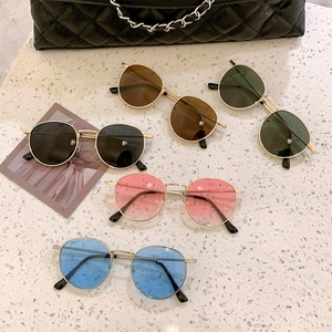 Collection of retro small round metal sunglasses in five colors on marble surface