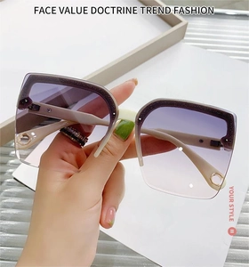 Detail view of purple gradient lens and cream white frame with circular metal accent
