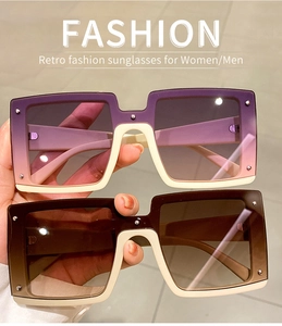 Close-up of oversized square sunglasses with gradient lenses and metal rivet details