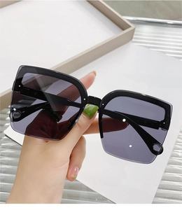 Detail of oversized square sunglasses with black glitter frames and purple gradient lenses