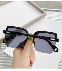 Detail of rimless oversized black sunglasses with silver metal temples and gradient lenses