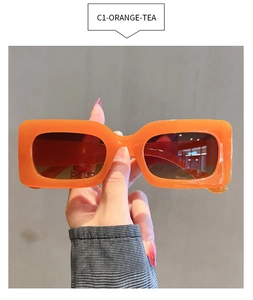 Detail of trendy orange square sunglasses with tea lenses and thick retro acetate frame