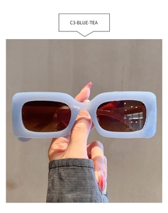 Detail view of rectangular blue sunglasses with tea-tinted lenses and thick retro frame