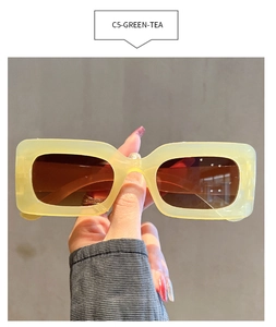 Detail of translucent green tea rectangular sunglasses with gradient brown lenses