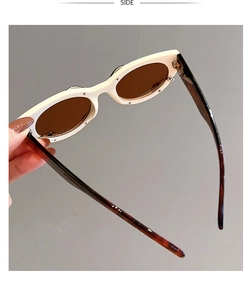 Detail view of oval white frame sunglasses with leopard print tortoiseshell temples