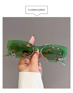 Detail of green cat-eye sunglasses featuring silver metal thorn elements and thick frames