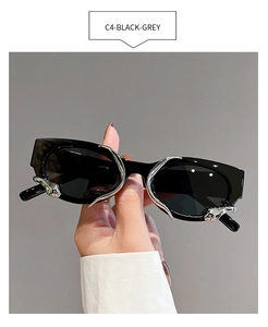 Close-up of futuristic black sunglasses featuring silver metal claw-style accents