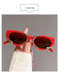 Detail of red cat-eye sunglasses with silver fluid metal trim and tea tinted lenses