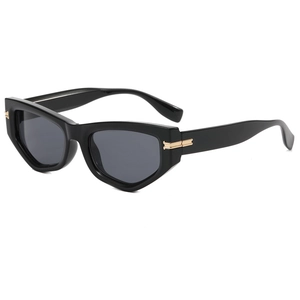Close-up of cat-eye sunglasses with sleek black frame and golden metal hinge detail