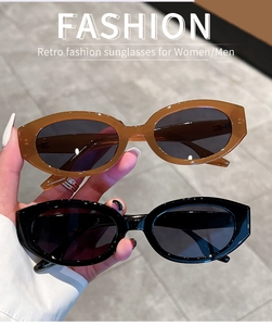 Close-up of retro oval sunglasses in amber and black colors with thick resin frames