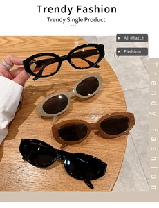 Flat lay of oval vintage fashion sunglasses in multiple colors on a wooden surface
