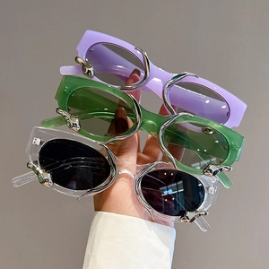 Retro futuristic cat-eye sunglasses with purple, green, and clear frames and silver metal accents