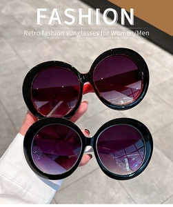 Detail view of two oversized round retro sunglasses with red and white inner frames