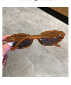 Detail view of oval tortoise sunglasses featuring deep grey lenses and silver metal temple accents