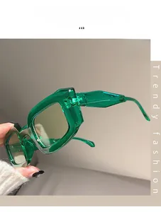 Close-up of trendy green transparent oversized square sunglasses with dark lenses