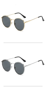 Detail view of vintage round sunglasses with gold and silver metal frames and dark lenses