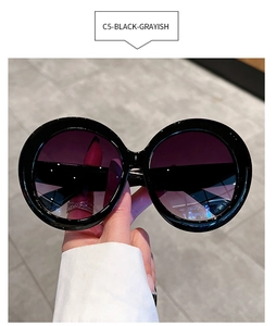 Detail of round oversized sunglasses with C5 black frames and gradient purple gray lenses