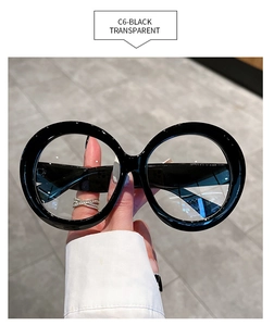 Detailed close-up of retro oversized round glasses in glossy black with clear lenses