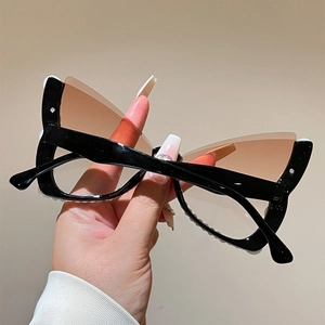 Detail of cat-eye sunglasses with pearl-embellished black frame and gradient lenses