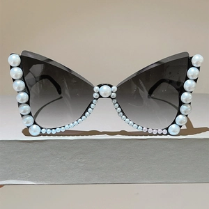 Detailed close-up of butterfly frame sunglasses with elegant pearl embellishments