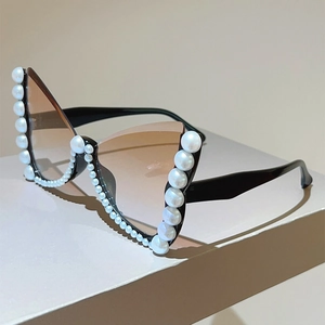Detail of butterfly cat-eye sunglasses with pearl embellishments and gradient lenses