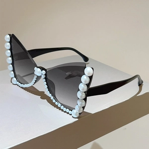 Detail of cat eye sunglasses with black frame and elegant white pearl embellishments