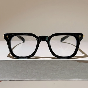 Detailed close-up of cat-eye black metal frame with gold diamond-shaped metal accents