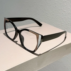 Detail view of cat-eye glasses with brown color-block accents on a geometric black frame