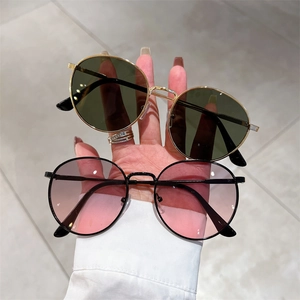 Retro round metal sunglasses in gold and black frames with gradient colored lenses