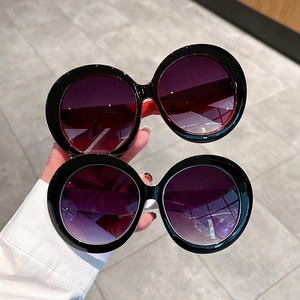Fashion oversized round sunglasses in black with red and cream temples and gradient lenses