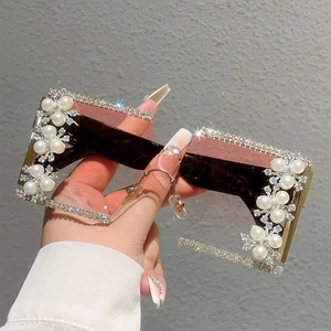 Close-up of oversized rimless square sunglasses with luxury rhinestone and pearl accents