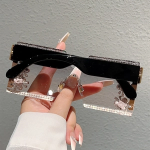 Close-up of oversized rimless square sunglasses with sparkling rhinestones and black temples