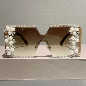 Detail of luxury rimless square sunglasses with rhinestone edges and pearl floral accents