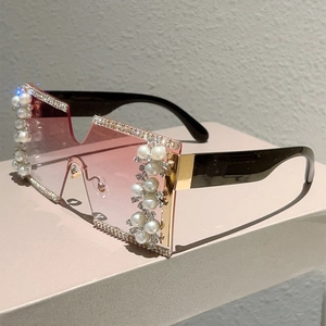 Detail of rimless square sunglasses with pink gradient lenses, rhinestones, and pearls