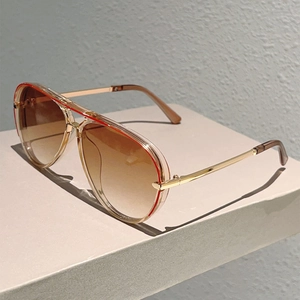 Detail of pilot sunglasses with champagne frame, red top line and gradient lenses