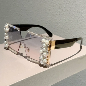 Detail of rimless square sunglasses with rhinestone edges and pearl accents on the lens