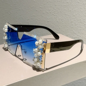Detail view of oversized rimless square sunglasses with blue gradient lenses and pearls