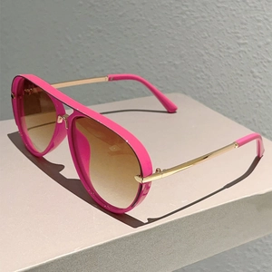 Close-up of pink pilot sunglasses with double bridge and golden metal temples