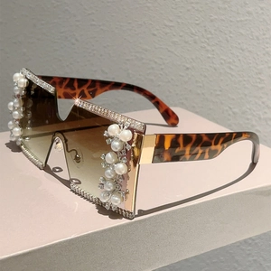 Close-up of oversized rimless sunglasses with luxury pearl and rhinestone embellishments