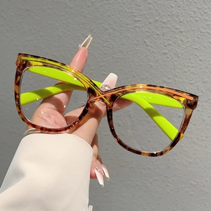 Oversized cat-eye glasses with tortoise frames and neon green temples in a 45-degree view