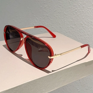 Detail of red transparent resin aviator frame and golden metal temples on sunglasses