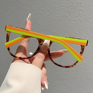 Detail of tortoiseshell cat-eye frames with neon orange and green striped temples