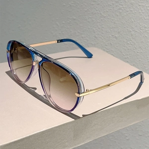 Detail of double bridge aviator sunglasses with blue-purple frame and golden metal temples